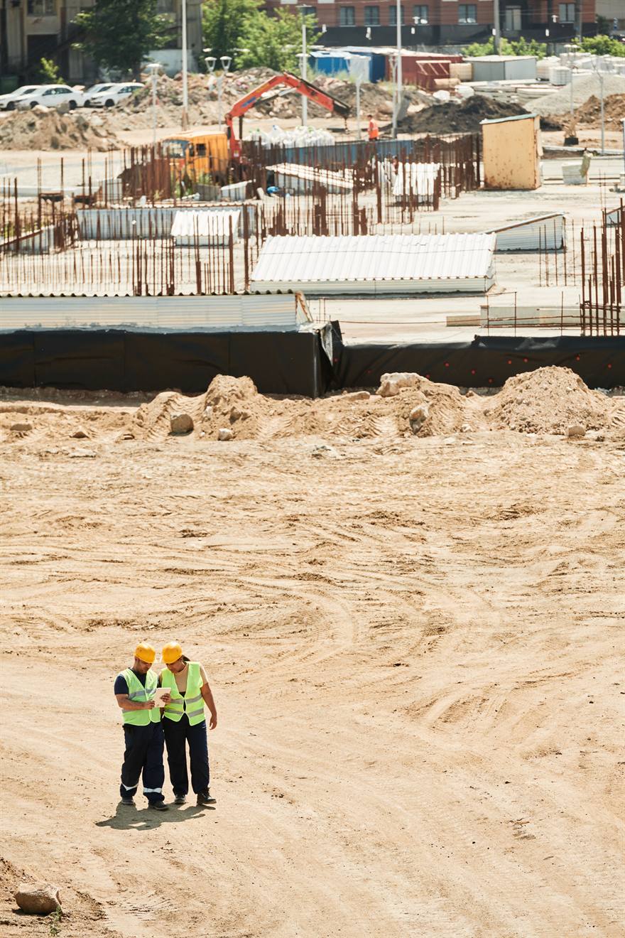 مهندسان يجريان فحص بناء رقميًا عبر جهاز لوحي في الموقع